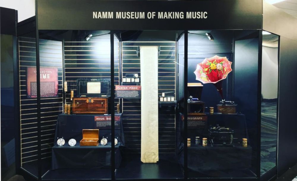Museum display with phonographs, player piano rolls, and music boxes